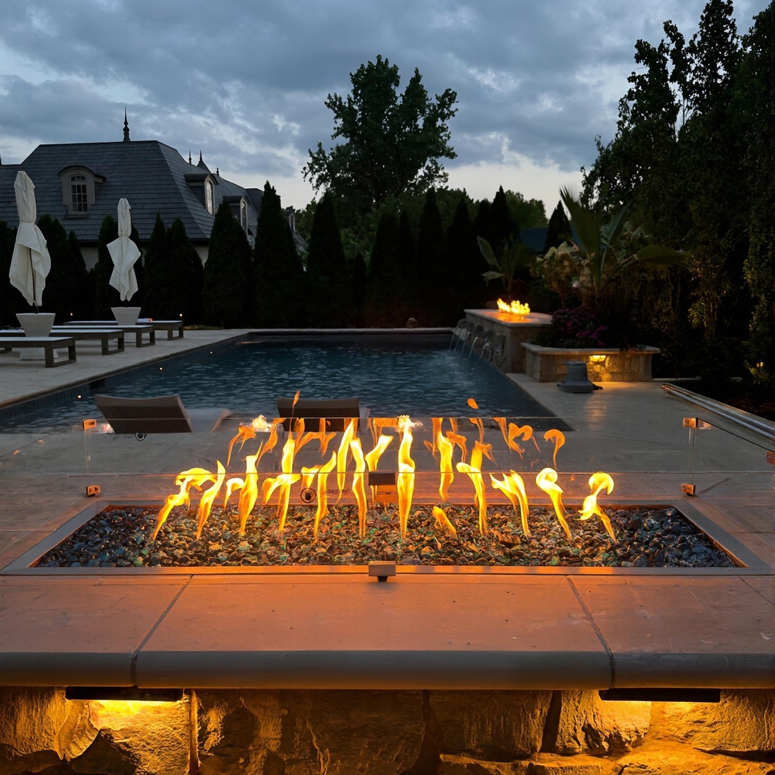 Luxury custom pool with fire pit and water features built by Inception Pools in Columbus, Ohio